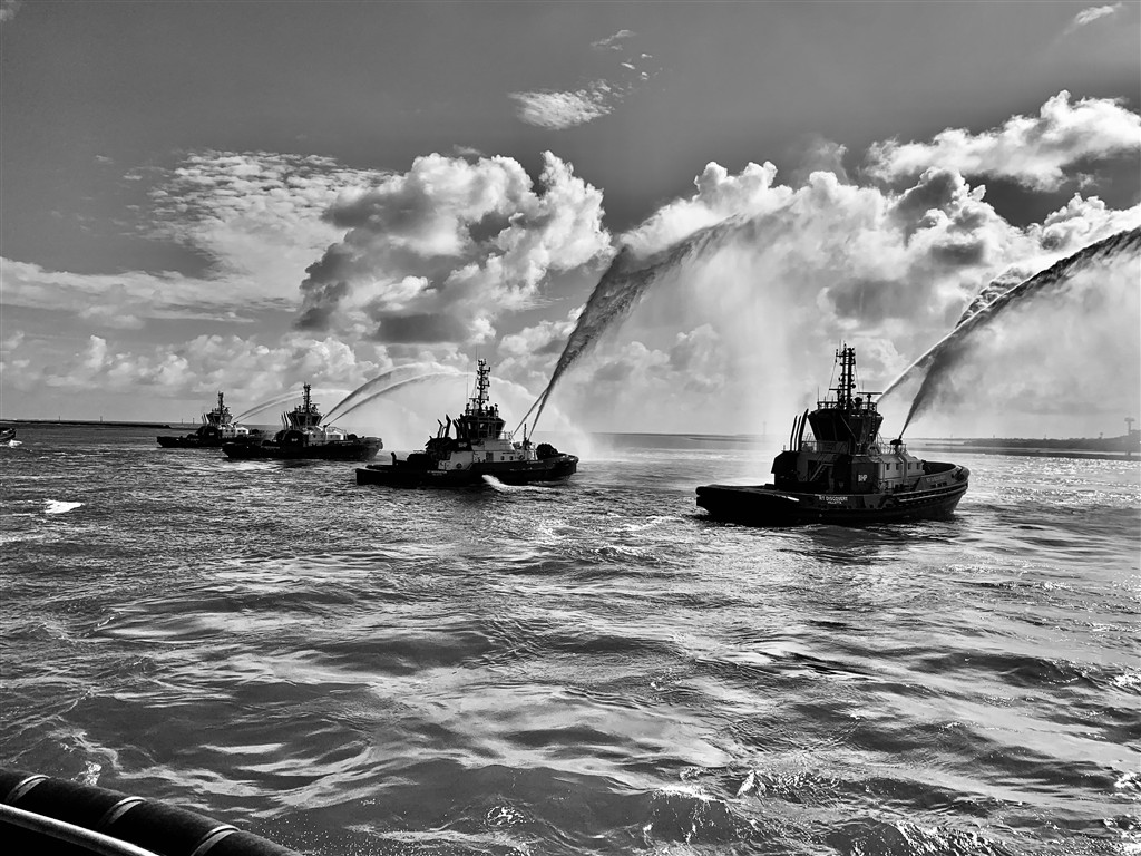 Fleet of tugboats performing a water cannon salute
